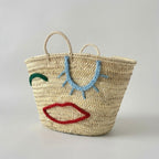 Woven Straw Market Tote Bag with Embroidered Winking Face Design