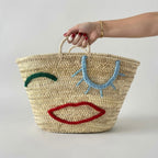Woven Straw Market Tote Bag with Embroidered Winking Face Design
