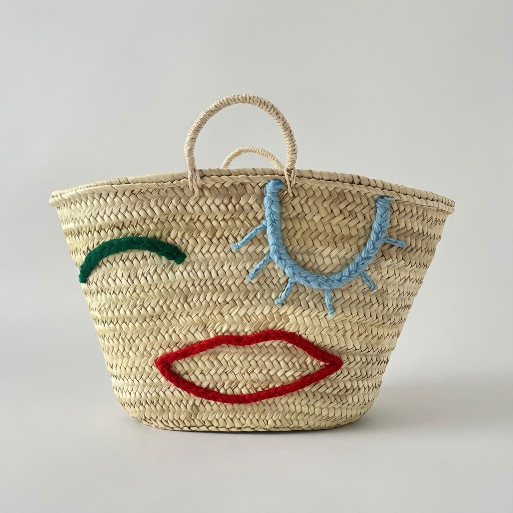 Woven Straw Market Tote Bag with Embroidered Winking Face Design